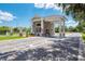 Community gatehouse with brick facade, white pillars, and tile roof on a sunny day at 13241 Scrub Jay Ct, Port Charlotte, FL 33953