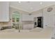 Bright kitchen with stainless steel appliances, white cabinets, tile backsplash, and open to dining room at 13241 Scrub Jay Ct, Port Charlotte, FL 33953