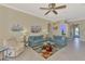 Cozy living room with comfortable sofas, ceiling fan, and stylish decor and access to the front entrance at 13241 Scrub Jay Ct, Port Charlotte, FL 33953
