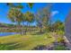 Lush backyard with palm trees and peaceful lake views creates a private outdoor oasis at 15 Boca Royale Blvd, Englewood, FL 34223