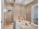 Bathroom featuring elegant fixtures, wallpaper, and a glass-enclosed shower at 15 Boca Royale Blvd, Englewood, FL 34223