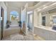 Elegant main bathroom featuring a soaking tub, separate vanities, and natural light at 15 Boca Royale Blvd, Englewood, FL 34223