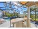 Outdoor bar area under screened-in patio overlooking the pool and landscaping at 15 Boca Royale Blvd, Englewood, FL 34223