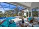 Stylish screened-in patio with comfortable seating overlooking the pool and landscaping at 15 Boca Royale Blvd, Englewood, FL 34223