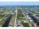 Aerial view showcases a waterfront community with homes nestled among canals and lush greenery at 15081 Aldama Cir, Port Charlotte, FL 33981