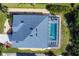 Aerial view showcases a home with a screened pool and meticulously maintained landscaping at 15081 Aldama Cir, Port Charlotte, FL 33981