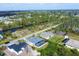 Aerial view captures a neighborhood with waterfront access and homes featuring screened pools at 15081 Aldama Cir, Port Charlotte, FL 33981