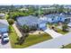 Aerial view of a home with manicured landscaping, a two-car garage and lush surrounding greenery at 15081 Aldama Cir, Port Charlotte, FL 33981