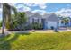 Inviting single-story home with mature palm trees and a well-kept lawn at 15081 Aldama Cir, Port Charlotte, FL 33981