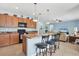 Open kitchen with an island, seating and a view into the adjacent living room at 15081 Aldama Cir, Port Charlotte, FL 33981
