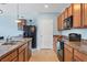 Well-lit kitchen with wood cabinetry and modern black appliances, great functionality and design at 15081 Aldama Cir, Port Charlotte, FL 33981