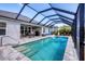 Relaxing screened-in pool with inviting steps, complemented by outdoor seating and lush greenery, great for leisure at 15081 Aldama Cir, Port Charlotte, FL 33981