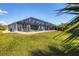 A spacious screened-in pool area and green lawn create an ideal backyard oasis at 15081 Aldama Cir, Port Charlotte, FL 33981