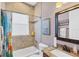 Tiled bathroom with shower-tub combo, granite countertop sink, and decorative wall art at 15610 Seafoam Cir, Port Charlotte, FL 33981