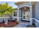 Inviting front entry with double glass doors, manicured landscaping, and a tiled walkway at 15610 Seafoam Cir, Port Charlotte, FL 33981