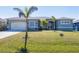 Charming single-story home featuring a lush lawn, a two-car garage, and attractive architectural details at 15610 Seafoam Cir, Port Charlotte, FL 33981