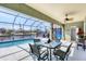 Spacious screened-in lanai with a pool, dining set, and waterfront views at 15610 Seafoam Cir, Port Charlotte, FL 33981