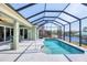 Screened-in pool area with waterfront views, dining set, and a covered lanai at 15610 Seafoam Cir, Port Charlotte, FL 33981