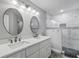 Bright bathroom with a double sink vanity, quartz countertops, and a glass enclosed shower with tiled walls at 170 Long Meadow Ln, Rotonda West, FL 33947