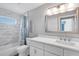 Bathroom featuring a single vanity, tiled shower with a bathtub, and a large mirror at 170 Long Meadow Ln, Rotonda West, FL 33947