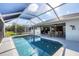 A stunning screened-in pool area featuring a sparkling pool, outdoor seating and clear blue skies at 170 Long Meadow Ln, Rotonda West, FL 33947