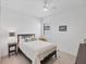 A well-lit bedroom featuring a comfortable bed, side table, and a bright window at 18575 Midsummer Pl, Venice, FL 34293