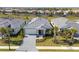 Charming single-story home with a gray-tiled roof, paver driveway and lush landscaping, providing excellent curb appeal at 18575 Midsummer Pl, Venice, FL 34293