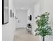 Bright hallway with a white door, tiled floor, and decorative art, enhanced by natural light and a stylish console table at 18575 Midsummer Pl, Venice, FL 34293