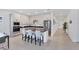 Contemporary kitchen featuring an island with seating, white cabinets, and stainless steel appliances, seamlessly connected to the living area at 18575 Midsummer Pl, Venice, FL 34293