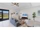 Bright living room with tile floors, a comfortable sofa, and a large sliding glass door, creating a relaxing and airy space at 18575 Midsummer Pl, Venice, FL 34293