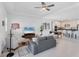 Open-concept living room featuring tile flooring, ceiling fan, and a modern kitchen at 18575 Midsummer Pl, Venice, FL 34293