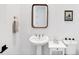 This powder room features patterned tile flooring, a pedestal sink, and a modern framed mirror at 18575 Midsummer Pl, Venice, FL 34293