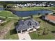 Stunning aerial view of a home with screened-in pool, manicured lawn, and nearby lake and golf course at 19 Windward Rd, Placida, FL 33946