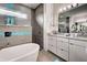 Modern bathroom featuring double vanities, a soaking tub, and a stylish chandelier at 19 Windward Rd, Placida, FL 33946