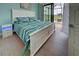 Charming bedroom with sliders to patio, golf course views, coastal decor, and wood-look flooring at 19 Windward Rd, Placida, FL 33946