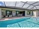 Back yard view of the pool with an outdoor seating area and sliding glass doors at 19 Windward Rd, Placida, FL 33946