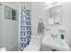 Bathroom featuring a tiled shower with a stylish blue and white patterned curtain at 1910 Greenlawn Dr, Englewood, FL 34223