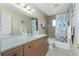 Well-lit bathroom with neutral color palette, spacious vanity, and stylish shower curtain, creating a relaxing spa-like atmosphere at 1910 Greenlawn Dr, Englewood, FL 34223