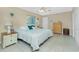 Cozy bedroom features a decorative ceiling fan and a comfy bed with stylish tropical-themed pillows and white quilt at 1910 Greenlawn Dr, Englewood, FL 34223