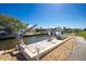 Dock featuring boat lifts, waterfront access, and outdoor lighting, perfect for boating enthusiasts at 1910 Greenlawn Dr, Englewood, FL 34223