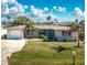 Charming single-story home with a well-manicured lawn, mature palm trees, and attached garage at 1910 Greenlawn Dr, Englewood, FL 34223