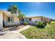 Attractive home with tidy landscaping, a bright blue front door, and a welcoming entrance at 1910 Greenlawn Dr, Englewood, FL 34223