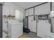 Functional laundry room with washer, dryer, overhead cabinets, and utility sink at 1910 Greenlawn Dr, Englewood, FL 34223