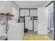 Bright laundry room with washer, dryer, storage cabinets, and adjacent bathroom for added convenience at 1910 Greenlawn Dr, Englewood, FL 34223