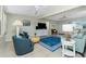 Spacious living room with blue accents, tile flooring, and a bright atmosphere at 1910 Greenlawn Dr, Englewood, FL 34223