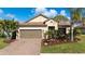 Charming single-story home featuring a well-manicured lawn, mature landscaping, and a brick-paved driveway at 209 Malina Ct, Nokomis, FL 34275