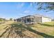 Wide backyard view showcasing a screened pool enclosure and beautiful waterfront at 23 Fairway Rd, Rotonda West, FL 33947