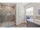 Bathroom with a glass shower, ceramic tile, wood look tile flooring, and gray cabinets with granite countertops at 23 Fairway Rd, Rotonda West, FL 33947