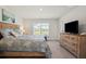 Bedroom with a wood bed, coastal themed bedding, a dresser with a TV, and light grey colored walls at 23 Fairway Rd, Rotonda West, FL 33947