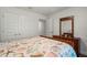 Bedroom with a wood bed, coastal themed bedding, a dresser, two closets, and light grey colored walls at 23 Fairway Rd, Rotonda West, FL 33947